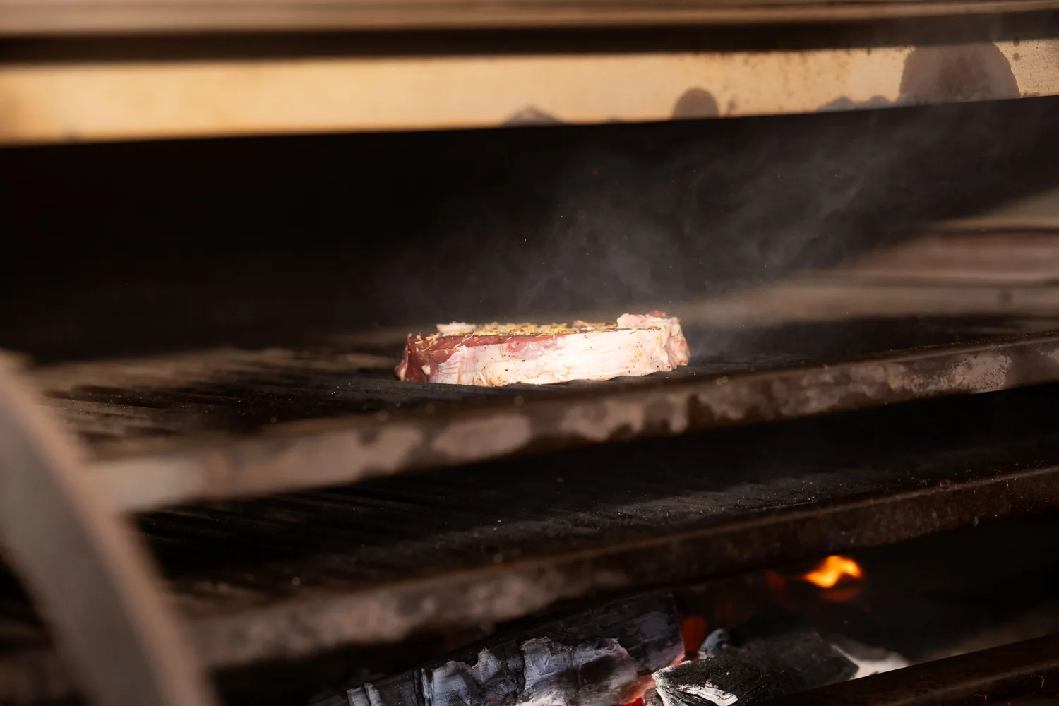 Steaks cooking over an open fire grill