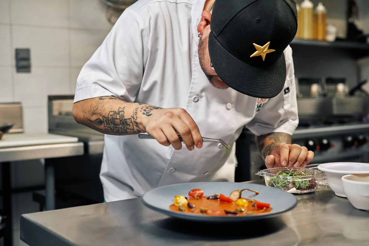 Chef plating a dish in an open kitchen